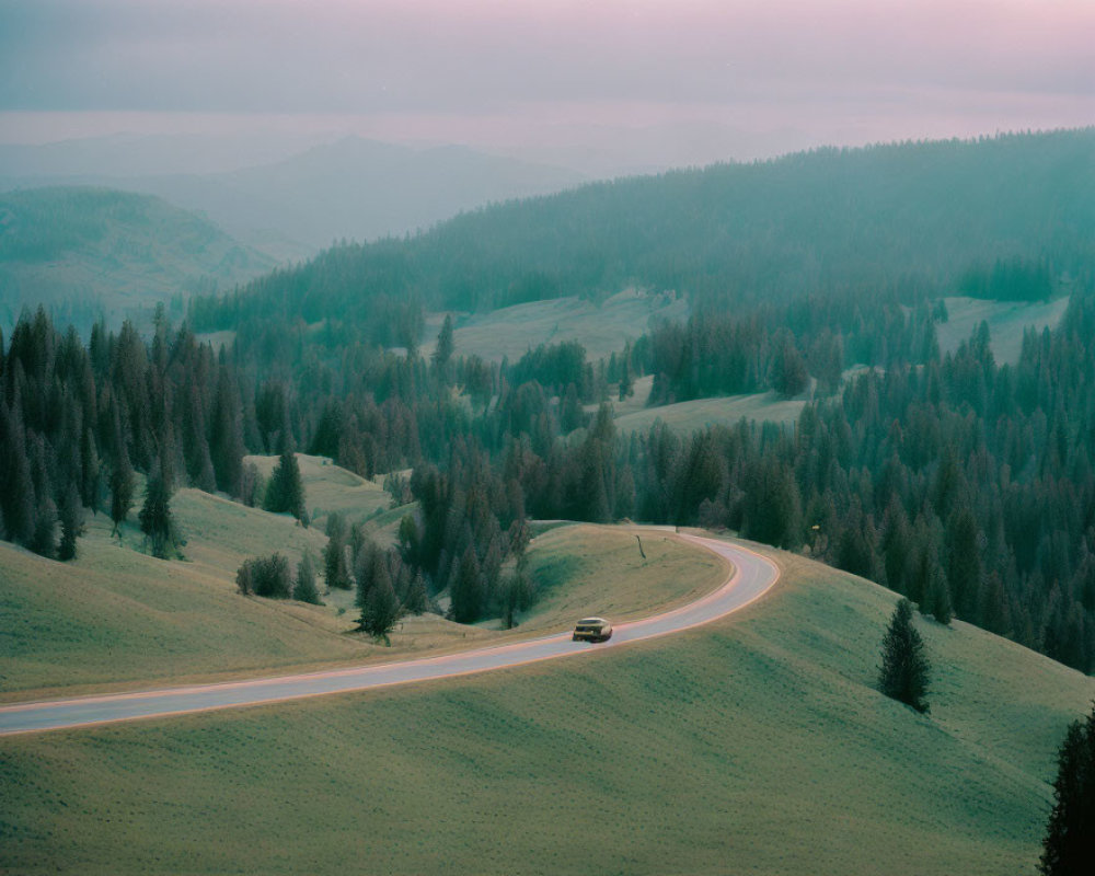 Tranquil hilly landscape with winding road and car