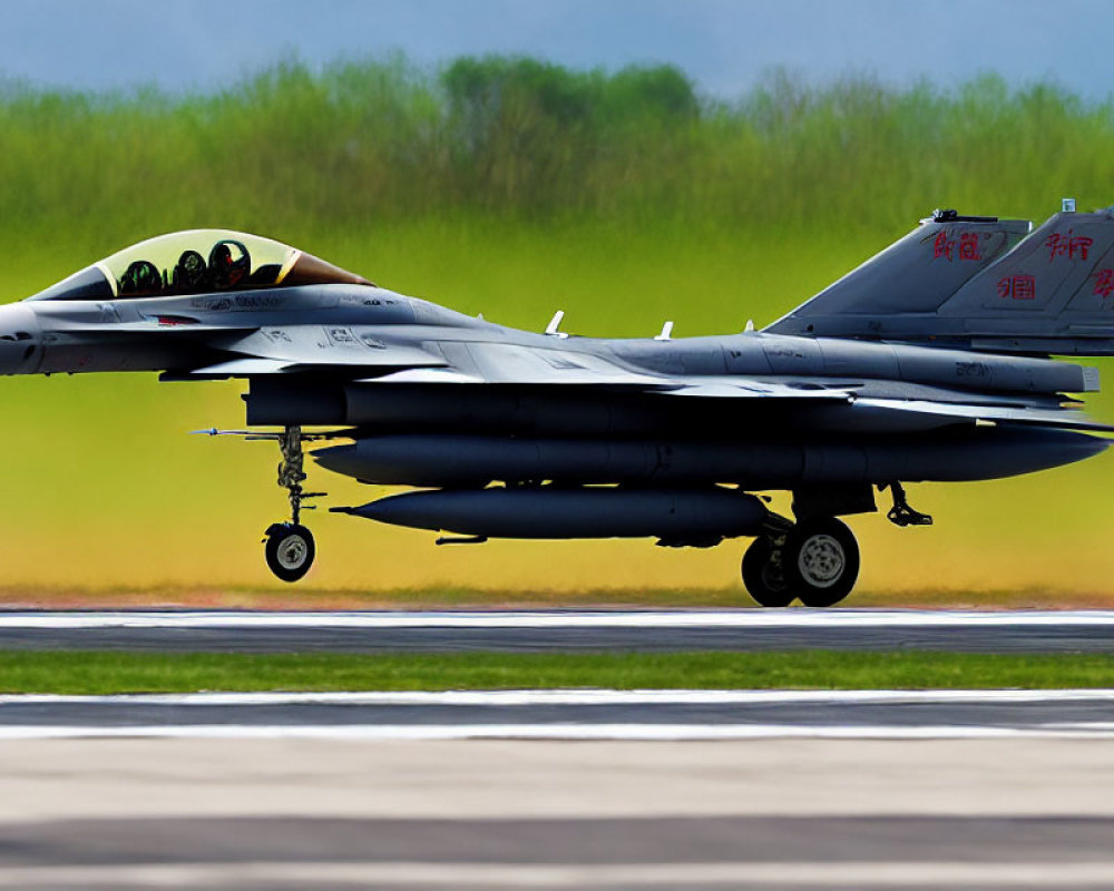 Military fighter jet with external payloads on runway, blurred background, Chinese characters on tail.