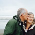 Elderly couple's tender kiss in soft watercolor style