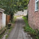 Whimsical forest path to brick tower in watercolor