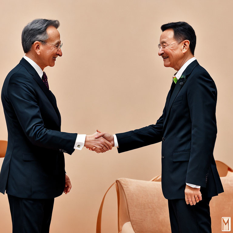 Businessmen shaking hands in peach-colored room