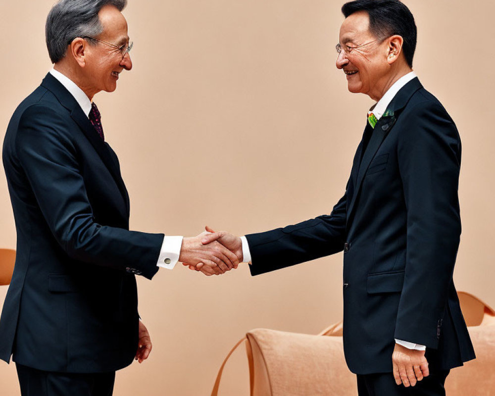 Businessmen shaking hands in peach-colored room