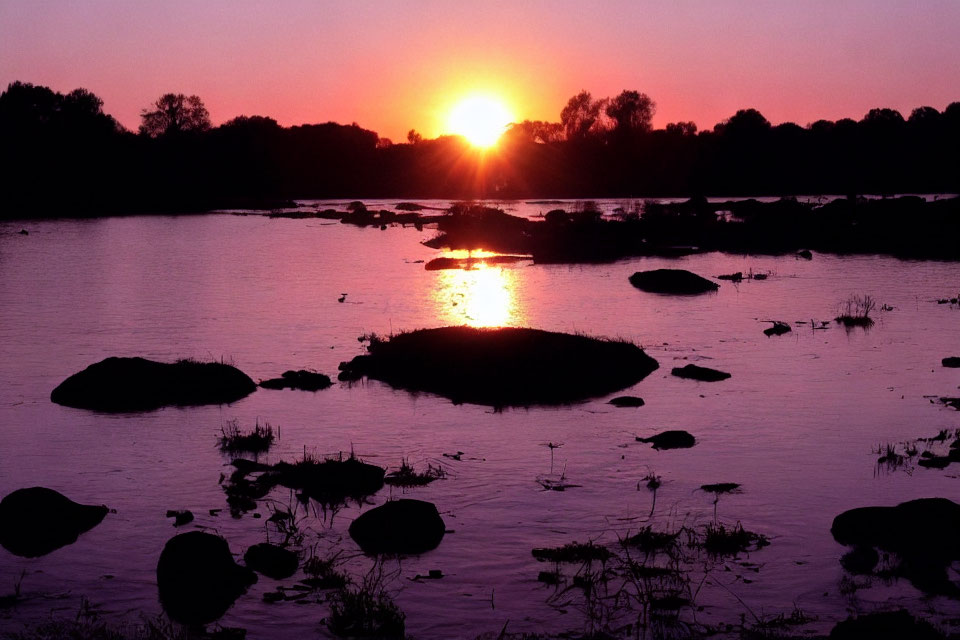 Tranquil river sunset with scattered rocks and islands