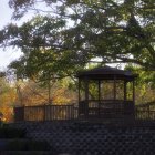 Tranquil Oriental garden with wooden pavilion in autumn foliage