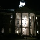 Classical pillars and golden door under radiant night sky