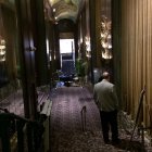 Luxurious corridor with golden columns, arched doorways, vaulted ceiling, and blue-gold