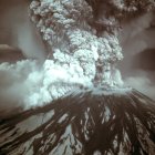 Dramatic volcanic eruption with fiery plume and blue lava against dark sky