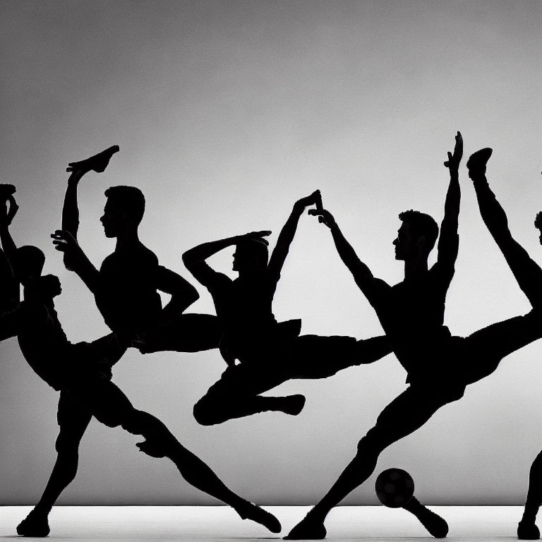 Dynamic Silhouetted Dancers in Performance Against Lit Background