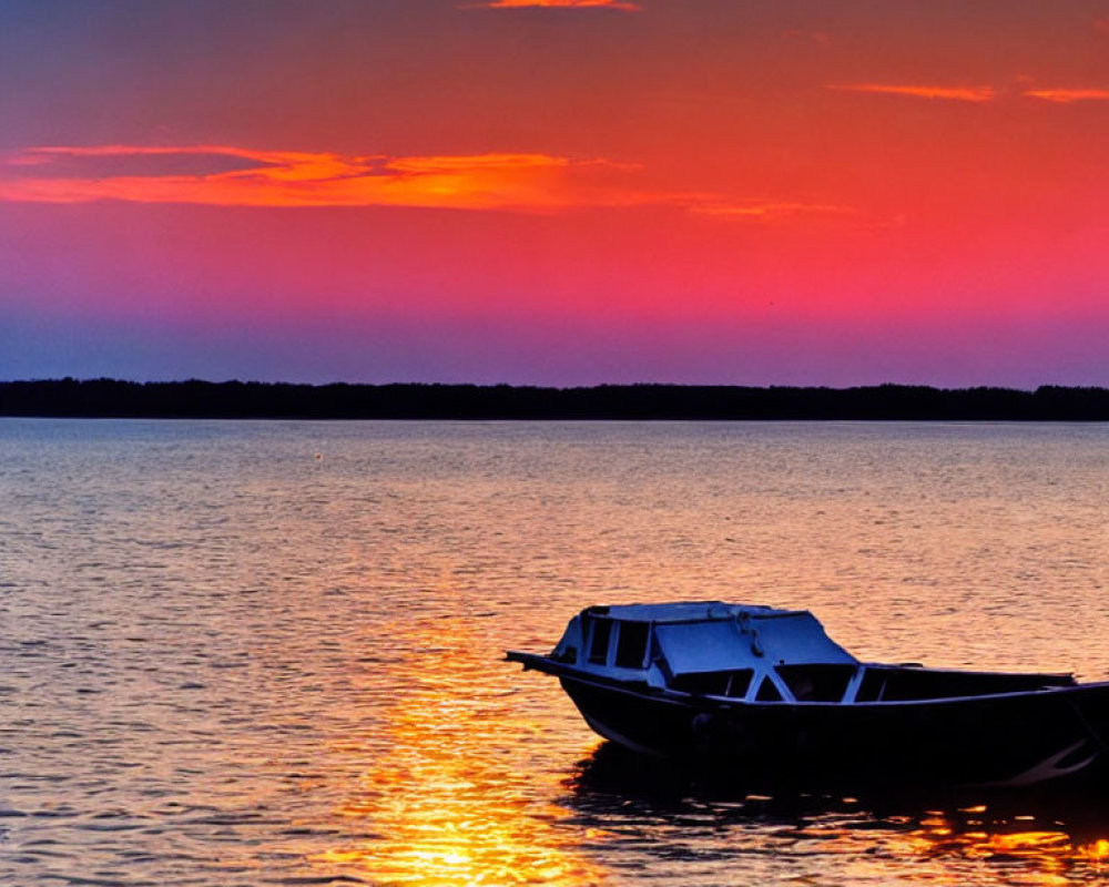 Tranquil sunset with orange and purple hues reflecting on water.