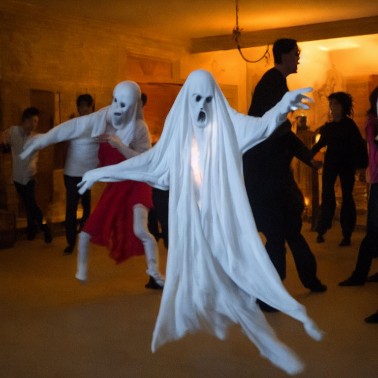 Two people in white ghost costumes with elongated faces dance in dimly lit room