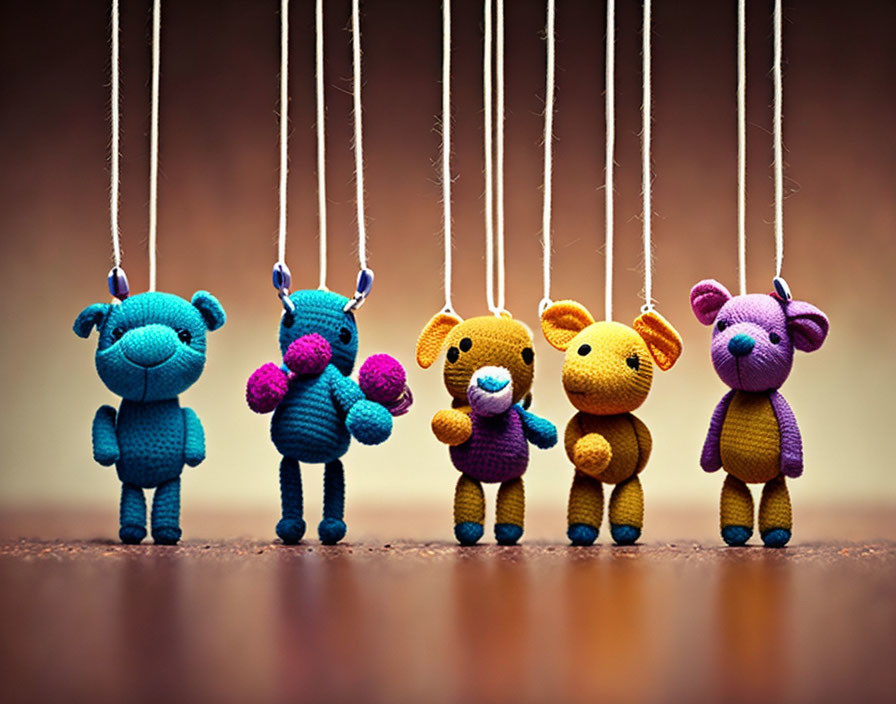 Colorful Knitted Animal Puppets on Strings Against Warm Background