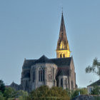 Gothic-style church with lit clock tower at twilight