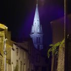 Medieval Village Night Scene with Illuminated Buildings & Church Spire