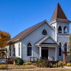 Whimsical blue house with ornate details in autumnal setting