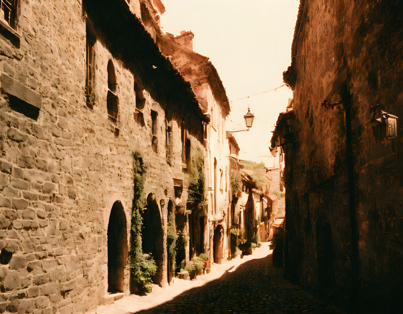 Historic cobblestone street in old European town with hanging lamps