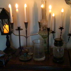 Elegant candle arrangement with lantern and greenery on textured wall