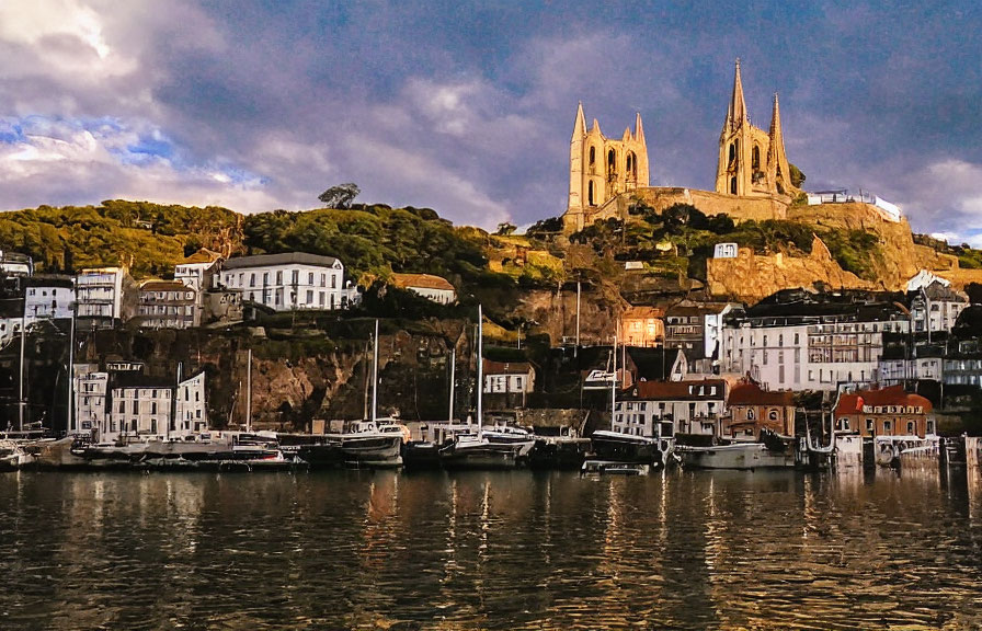 Scenic coastal town with cathedral, white buildings, and boats at sunset