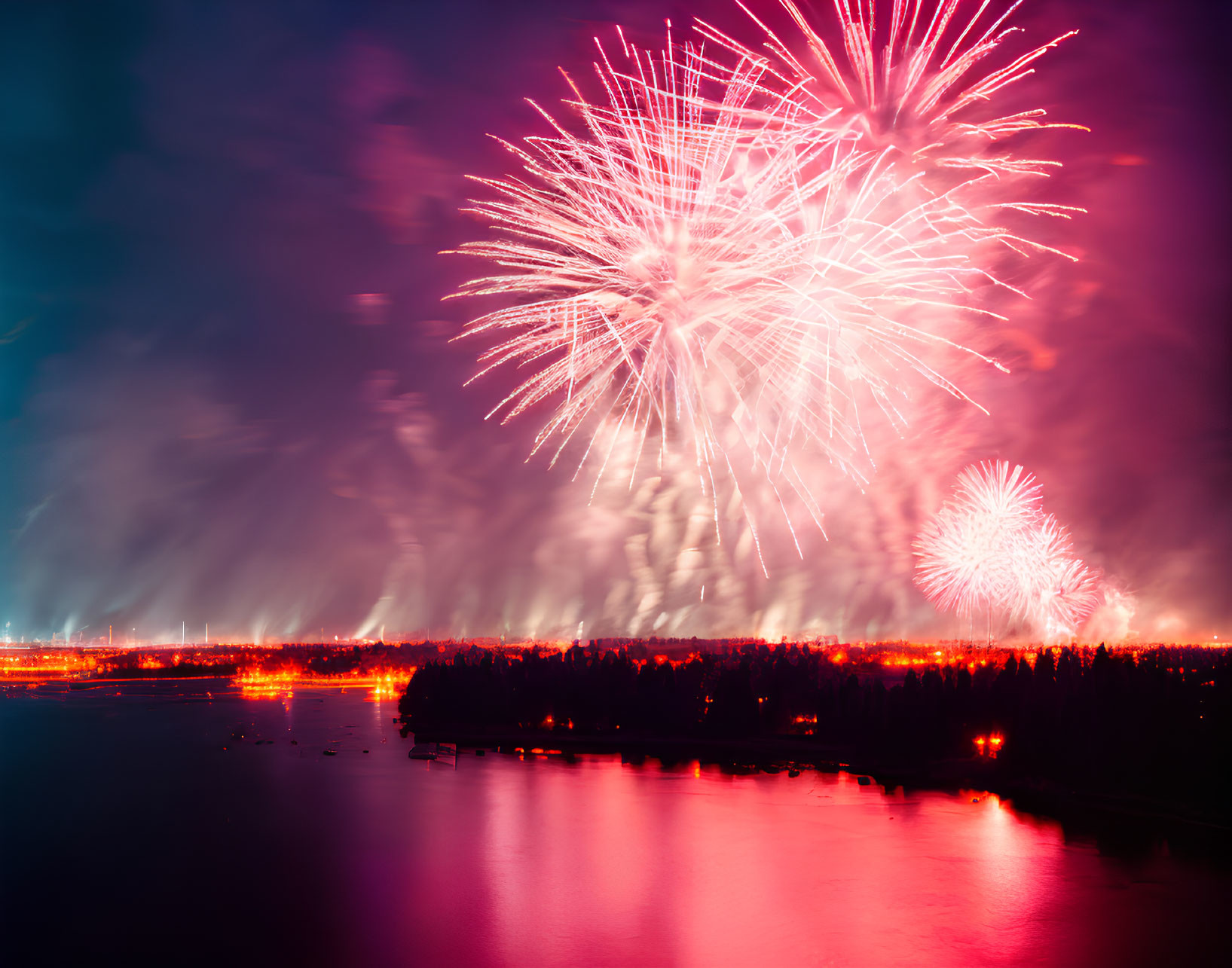 Colorful Fireworks Reflecting in Water Against Night Sky