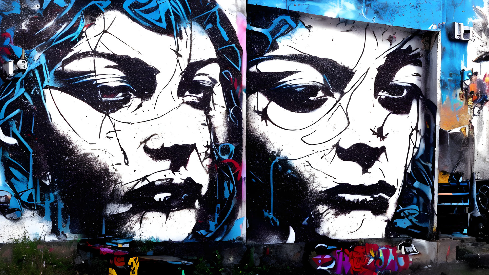 Monochrome woman's face mural with blue graffiti on wall