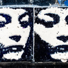 Monochrome woman's face mural with blue graffiti on wall