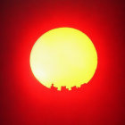 Dragon sculpture silhouette against mountain sunset.