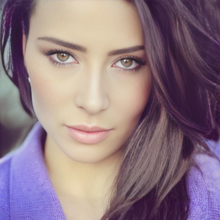 Portrait of woman with dark hair, hazel eyes, purple top