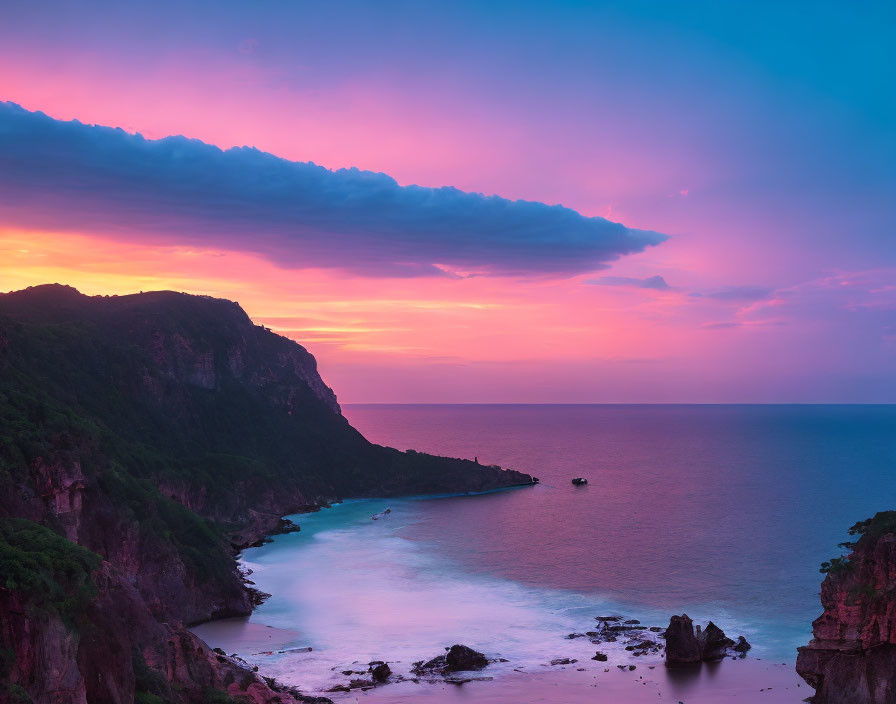 Scenic sunset with purple and pink clouds over serene sea and rocky coastline