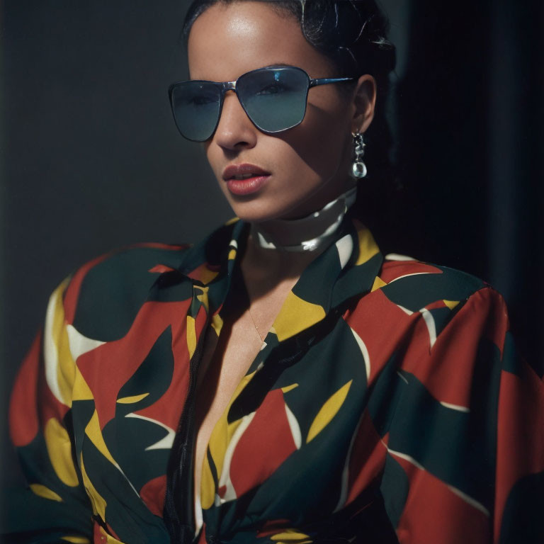 Woman in Blue Sunglasses with Slicked-Back Hair and Colorful Blouse