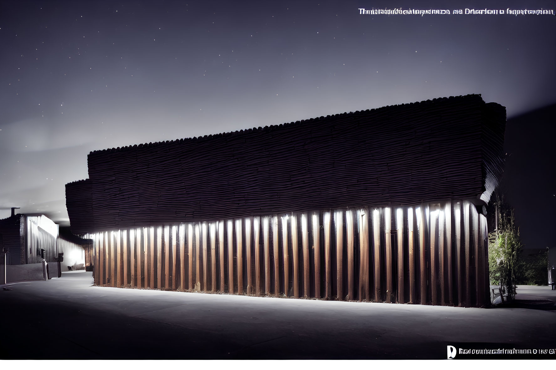 Modern building with ribbed facade and vertical lights under starry night sky