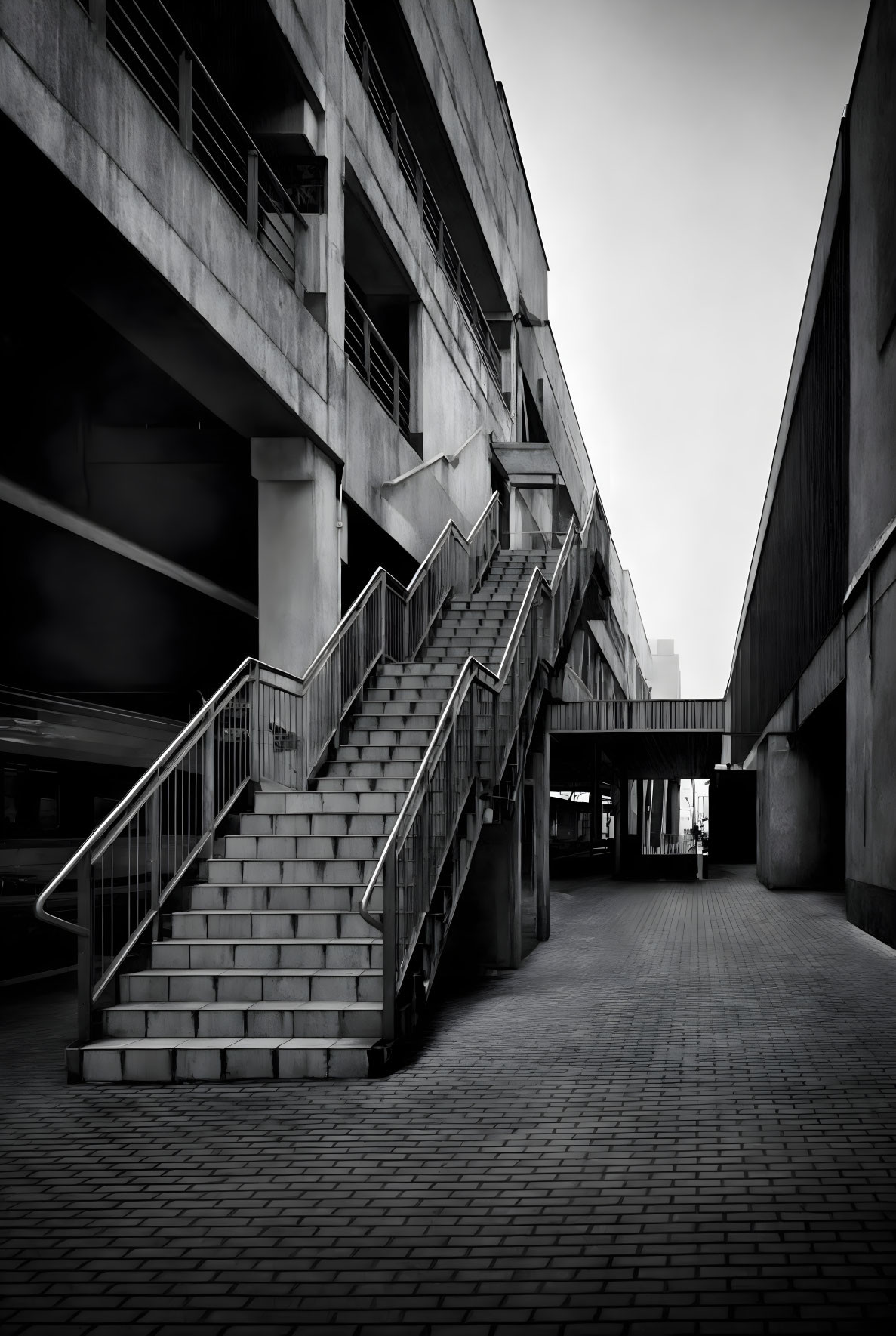 Monochrome urban staircase between buildings with architectural lines.