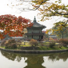 Tranquil lakeside village scene with autumn foliage and stone houses