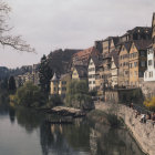 Historic canal scene: people in traditional attire loading boats amid mountains and classical architecture