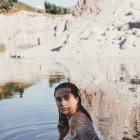 Young Woman in Rocky Pool Surrounded by Nature