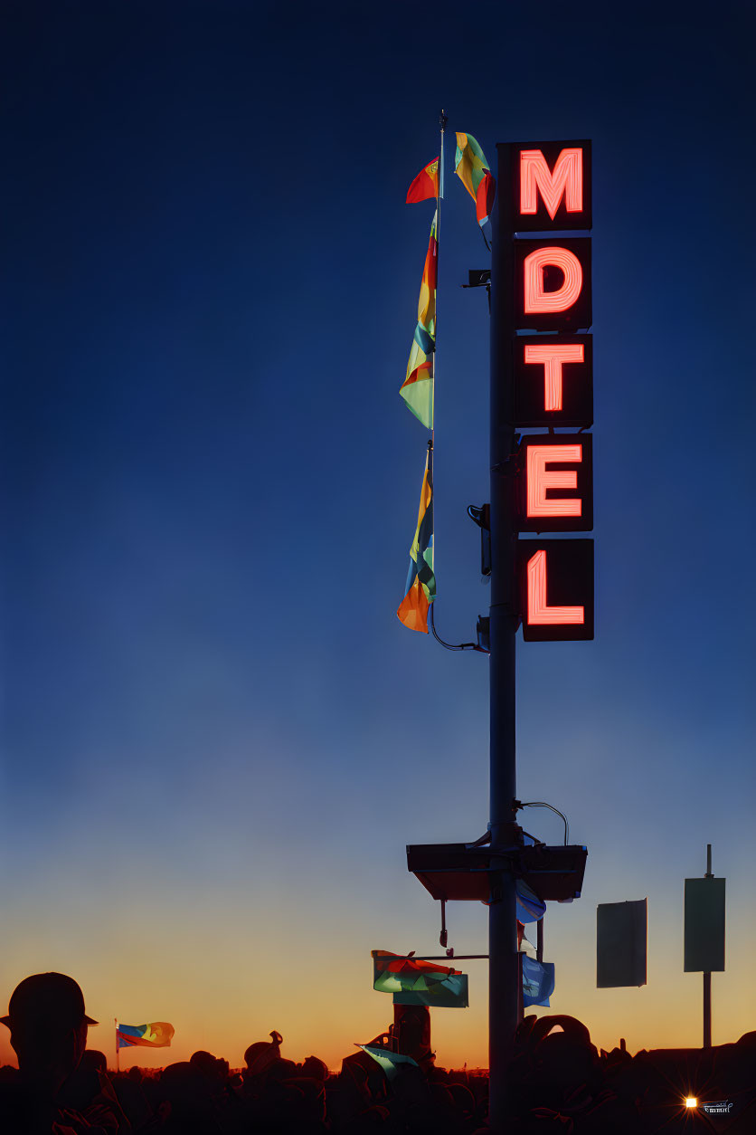 Neon 'MOTEL' Sign at Twilight with Flags and Silhouettes