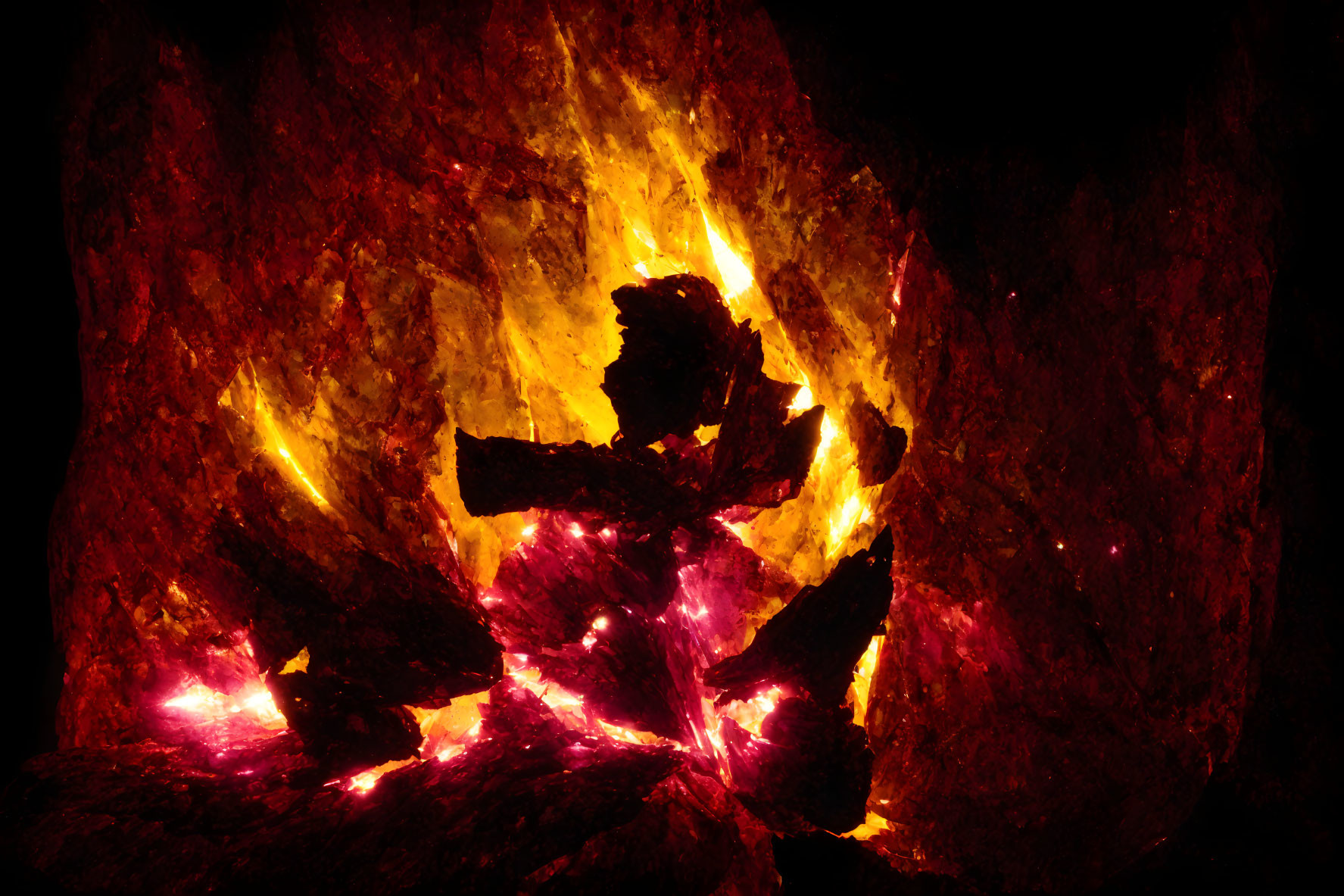 Vibrant campfire flames illuminating wood logs in dark setting