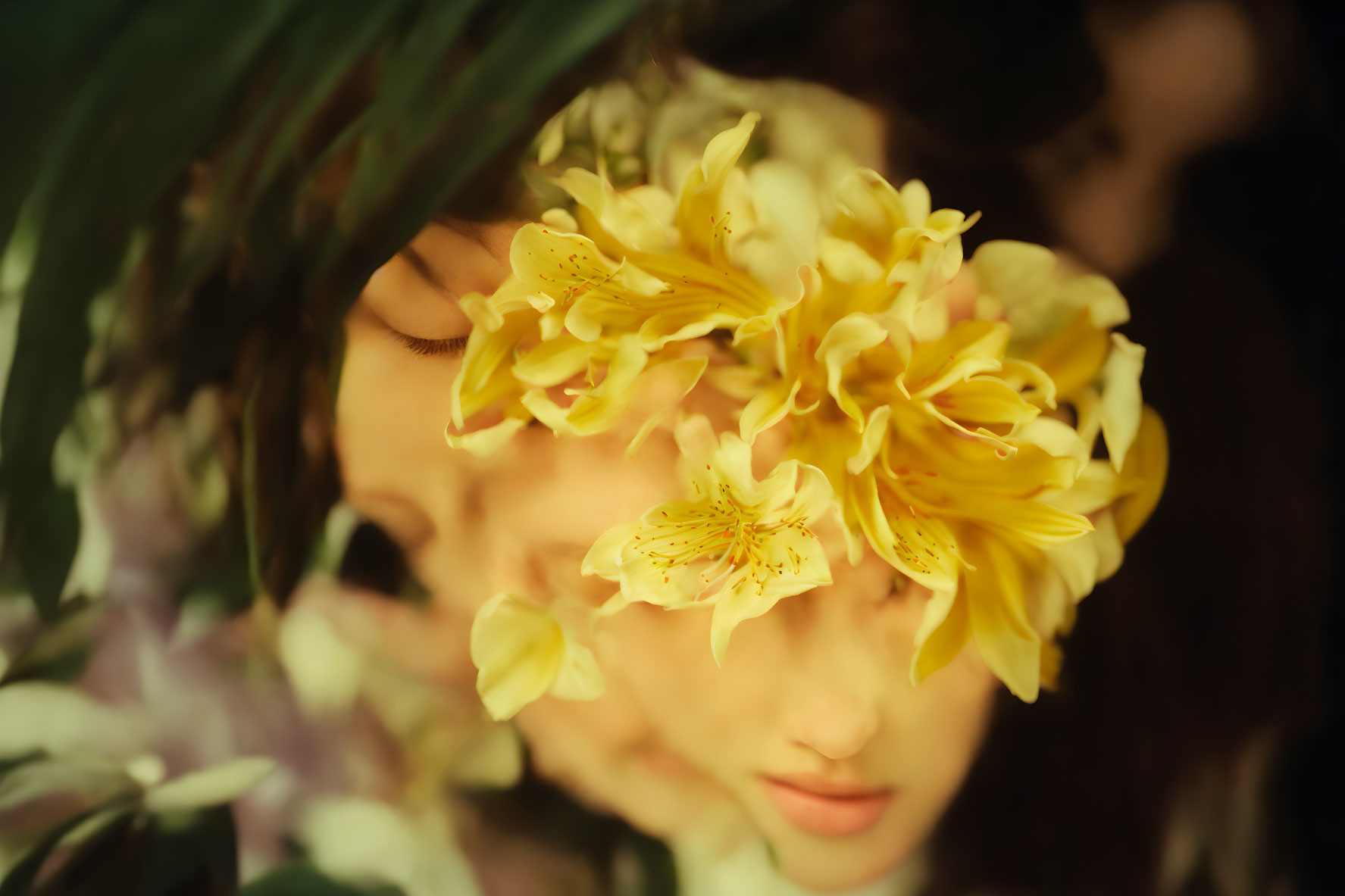 Face obscured by yellow flowers and greenery in soft focus