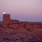 Surreal desert landscape: sandstone formations, castle, futuristic buildings, flying saucer