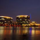 Cityscape with illuminated buildings reflected in water under dark sky