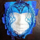 Symmetric ethereal face glass art with blue patterns and flowery border