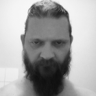 Monochromatic digital portrait of a bearded man with intense gaze and collared shirt