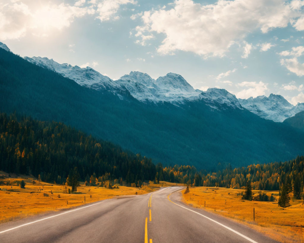 Scenic road amidst autumn trees and snow-capped mountains