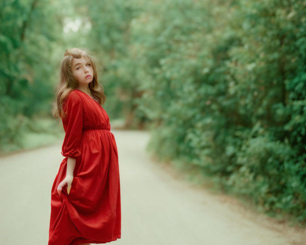 Woman in Red Dress Standing on Dirt Path in Lush Greenery