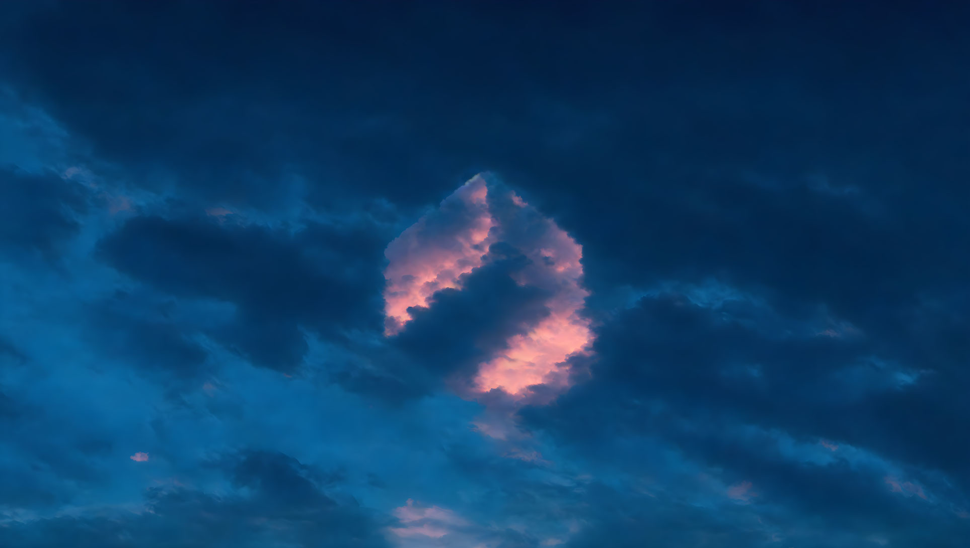 Pink Glow Cloud Against Dark Blue Twilight Sky