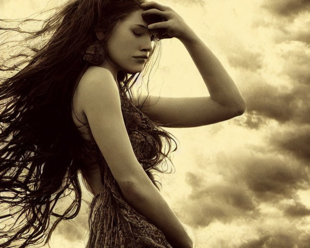 Profile of woman with long hair against dramatic cloudy sky