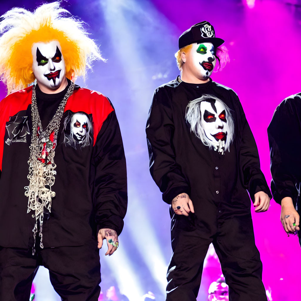 Vibrant hair clowns in black outfits with chain accessories