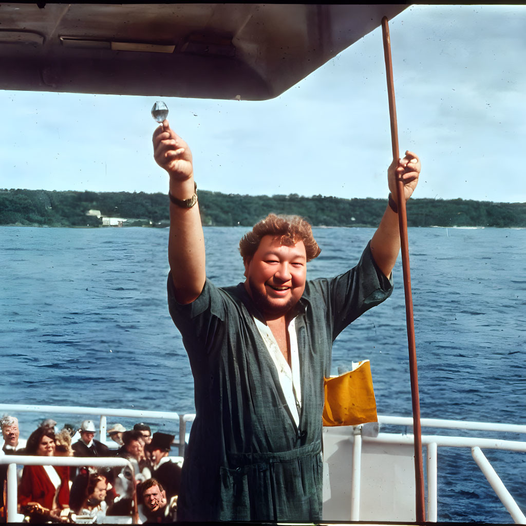 Person holding glass on boat with people on sunny day.