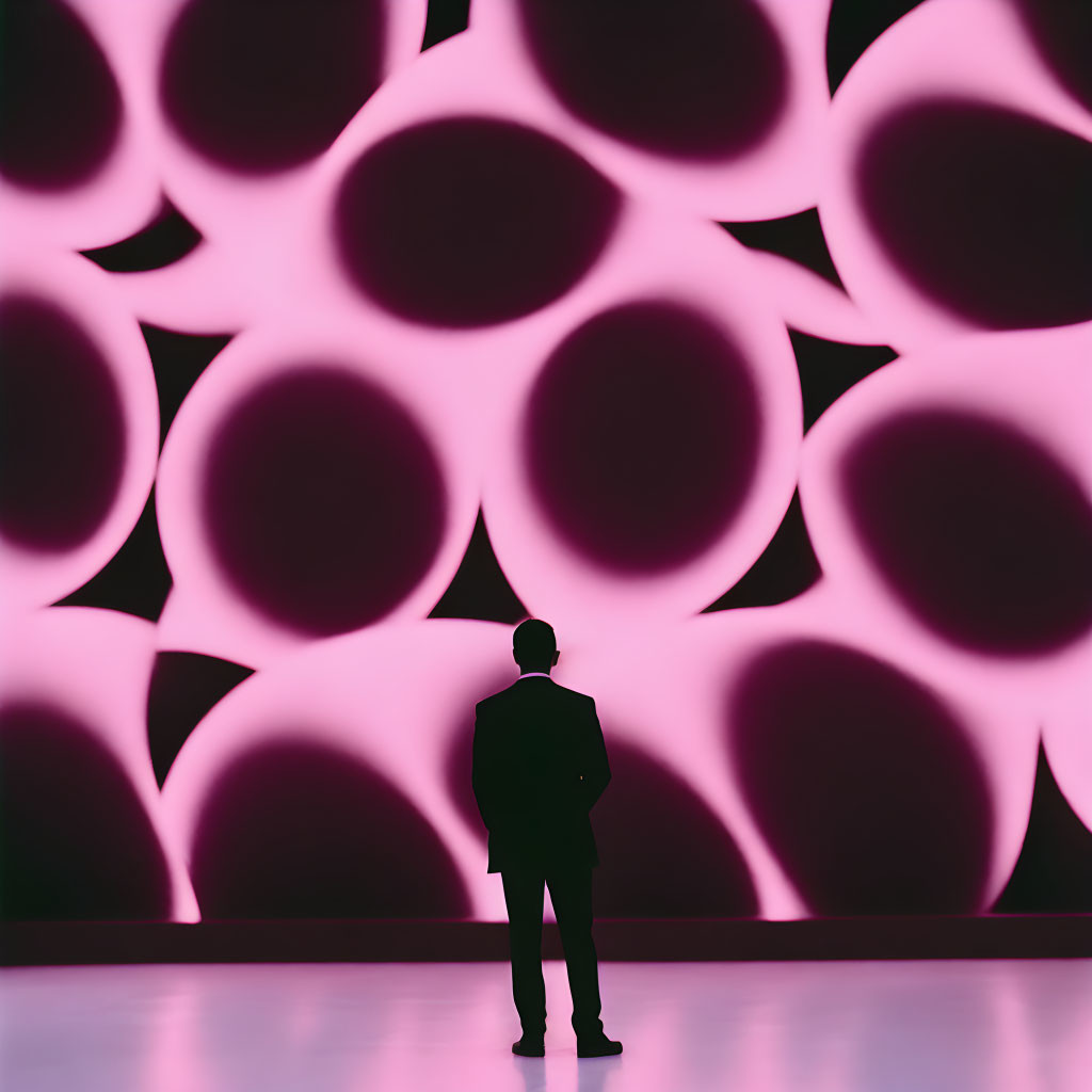 Silhouetted figure against vibrant pink and purple illuminated wall