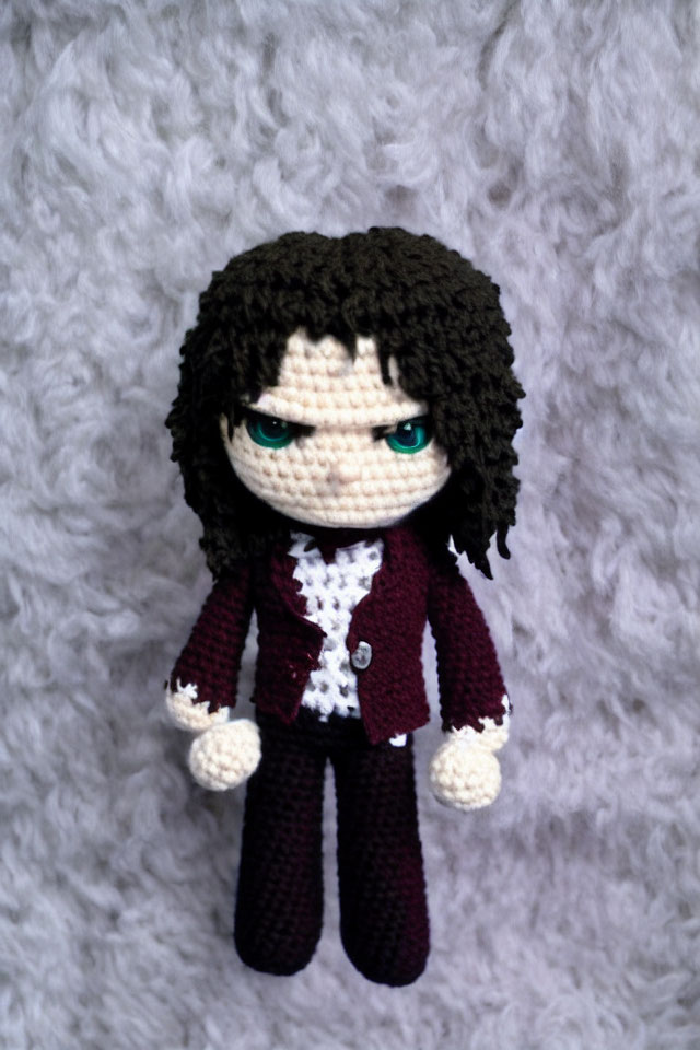 Handmade crochet doll with black curly hair, green eyes, red jacket, white shirt, maroon