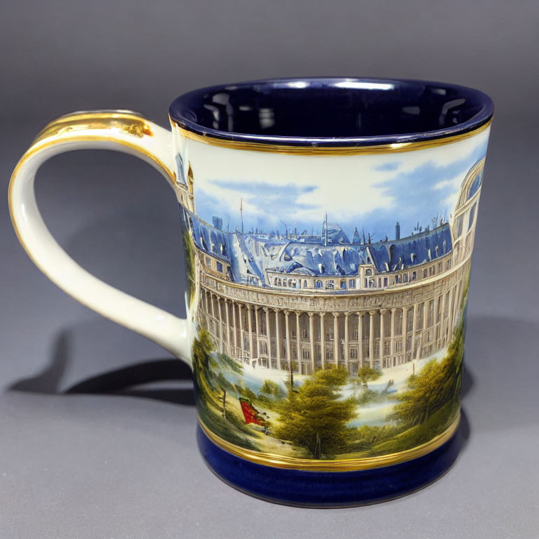 Gold-trimmed ceramic mug with historical building panorama and trees on white and blue background