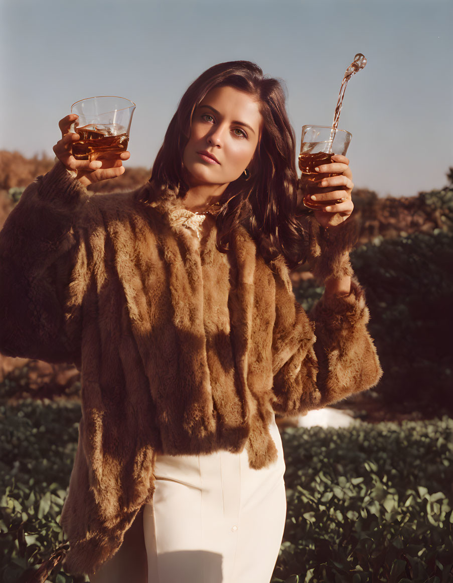 Woman in fur coat pouring whiskey into glass